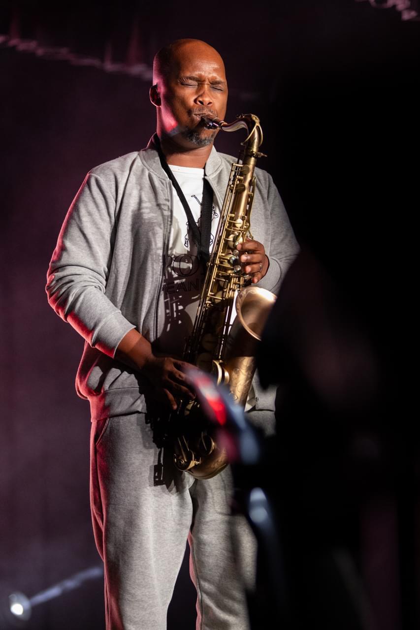 Saxophonist performing under red stage lights