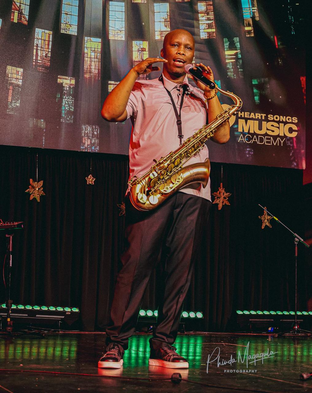 Heart Songs artist speaking to the audience with his saxophone